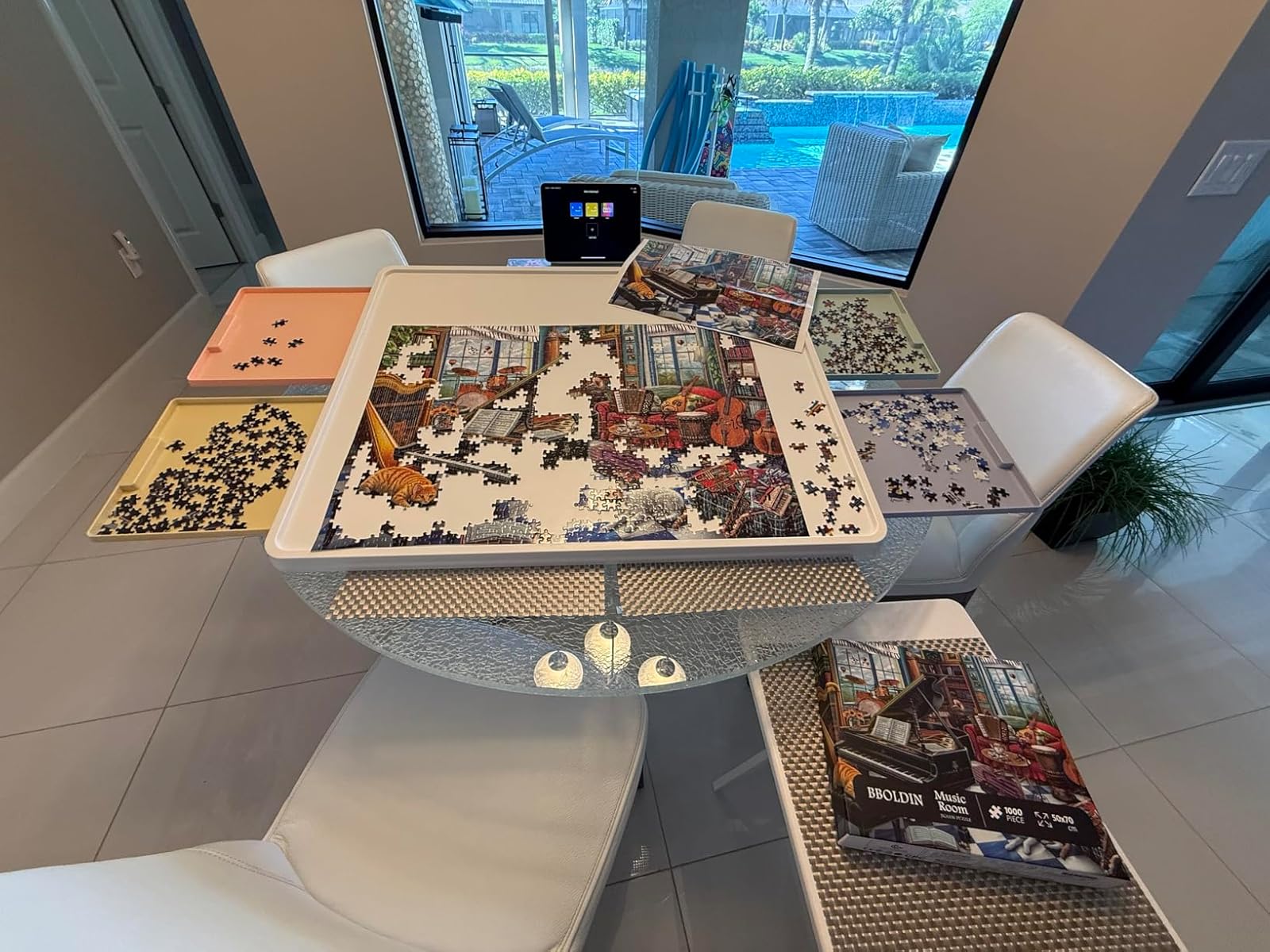 Customer review photo showing 1000-piece whiteboard puzzle board with colorful sorting drawers in use on a glass dining table