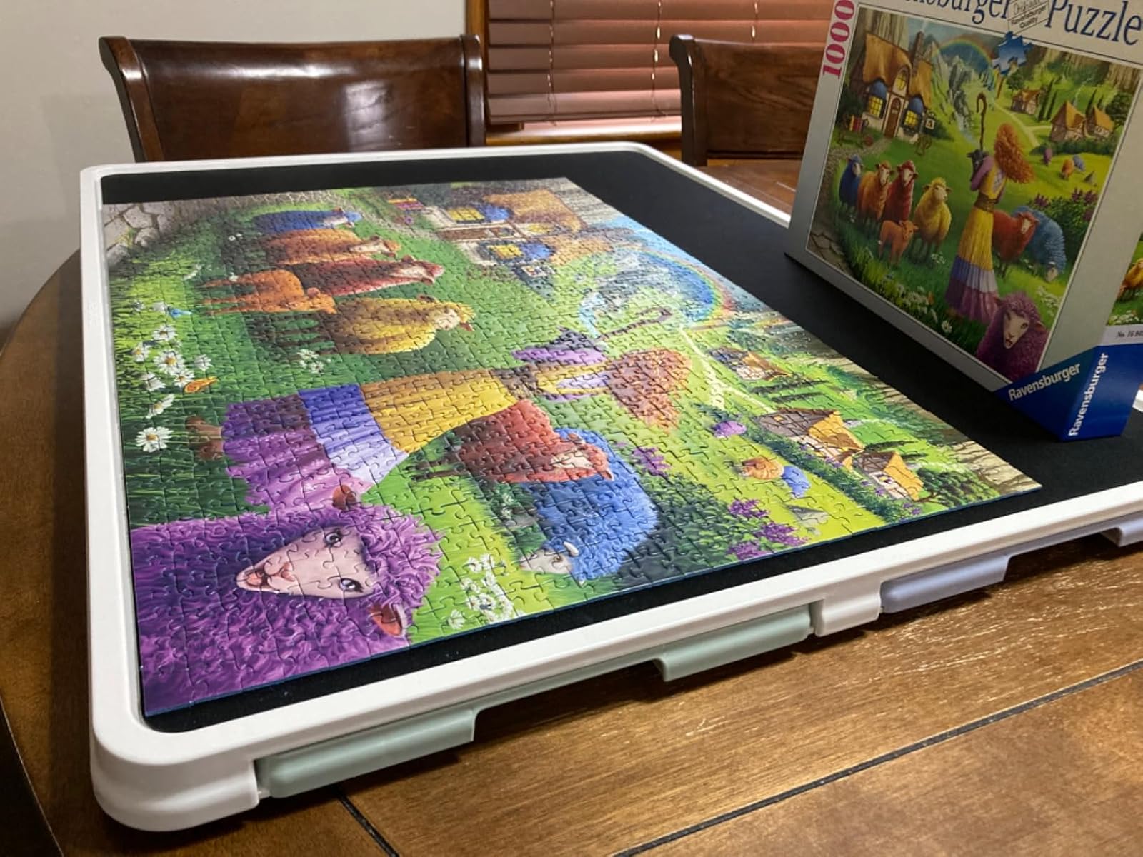 Playboda puzzle table showing finished colorful jigsaw puzzle on black surface with storage drawers