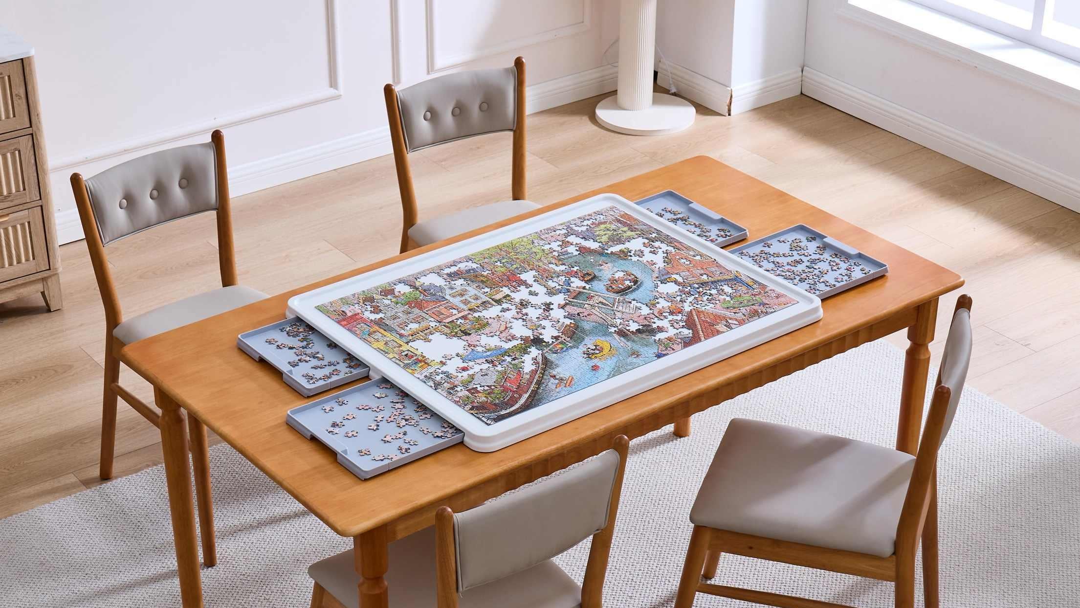 1500-piece whiteboard puzzle table with grey sorting drawers displayed on a dining table in a bright, minimalist home setting