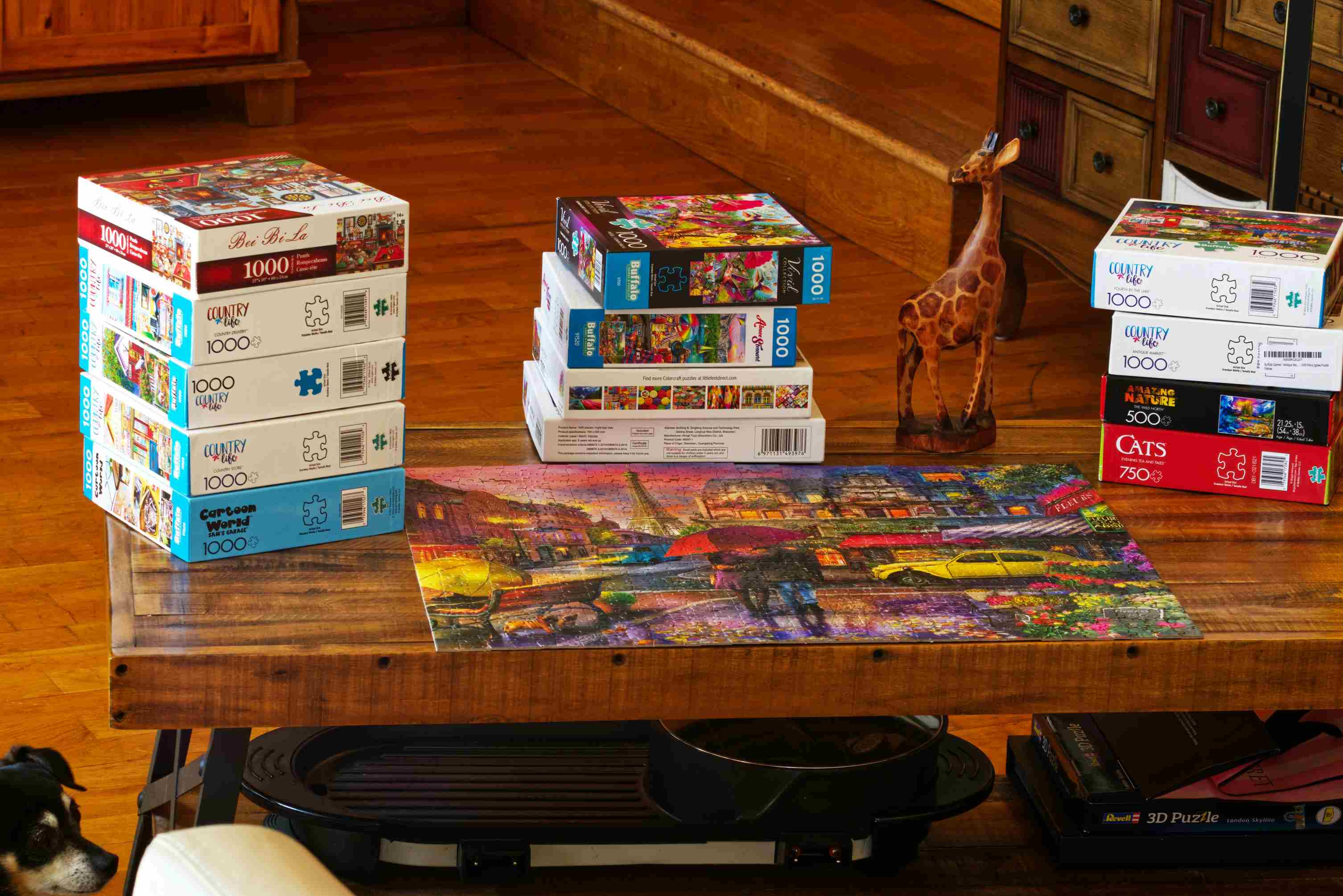 FAQ page background image showing stacked jigsaw puzzle boxes and completed colorful puzzle on wooden table