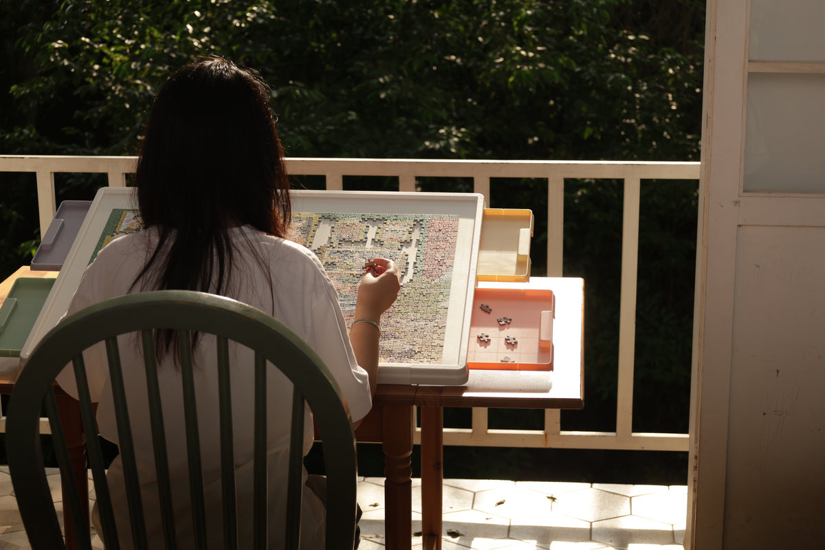 Lifestyle photo of puzzle table with sorting drawers used outdoors in natural light
